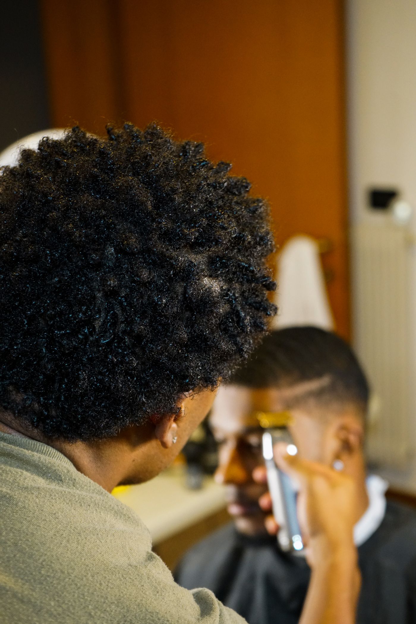 A barber styling a client’s hair during a focused appointment