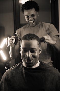 Two men enjoy a joyful moment in a barbershop, capturing the fun and happiness of the haircut experience.