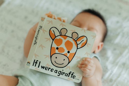 Baby Boy Lying Down with Book