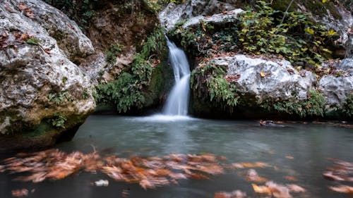 Waterfall and Creek among Large Rocks Photographed in Long Exposure 