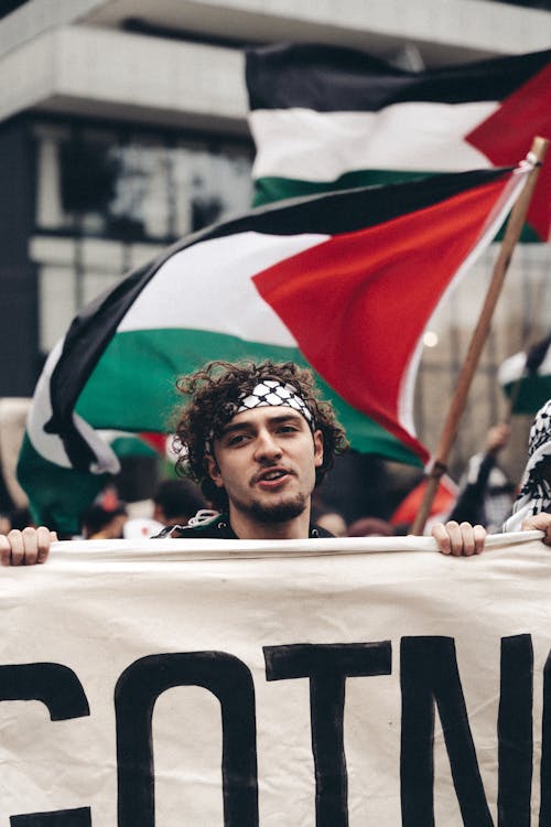 People Holding Palestinian Flags Protesting on the Street