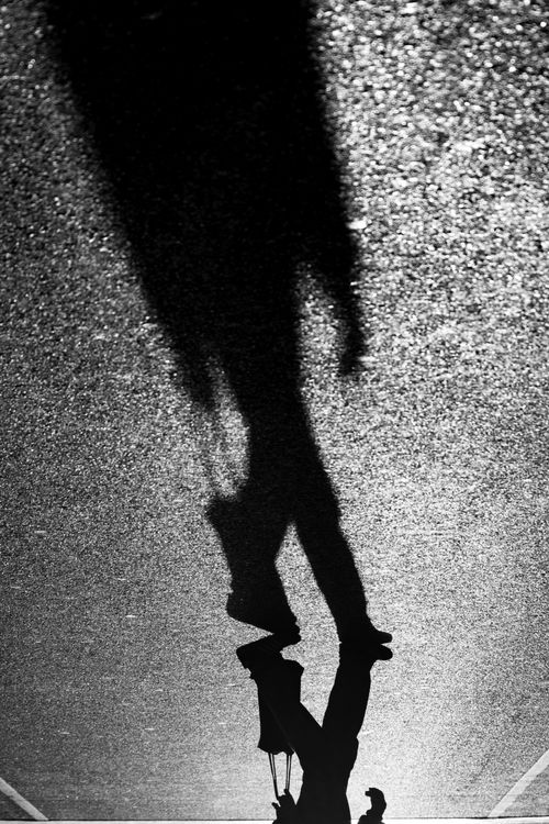 Free Artistic black and white silhouette of a person walking on textured pavement in Buenos Aires, Argentina. Stock Photo