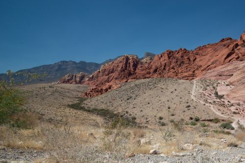 Free Stunning view of Red Rock Canyon with vibrant red cliffs and arid terrain under a clear blue sky. Stock Photo