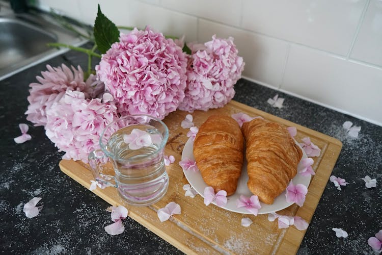 Purple Flowers, Water And Croissants