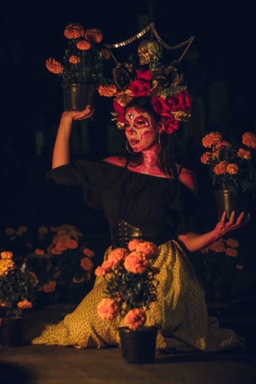 Free Colorful portrait of a woman in traditional Dia de los Muertos attire with floral decorations. Stock Photo