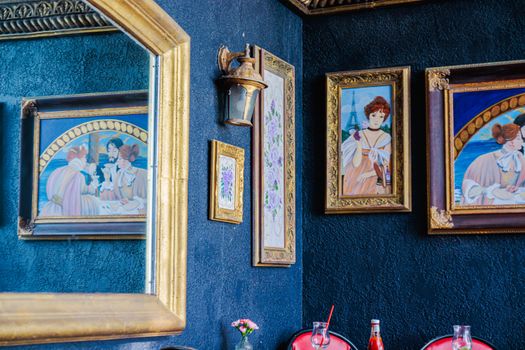 Artistic indoor setting featuring classic paintings and ornate mirror in vibrant colors.