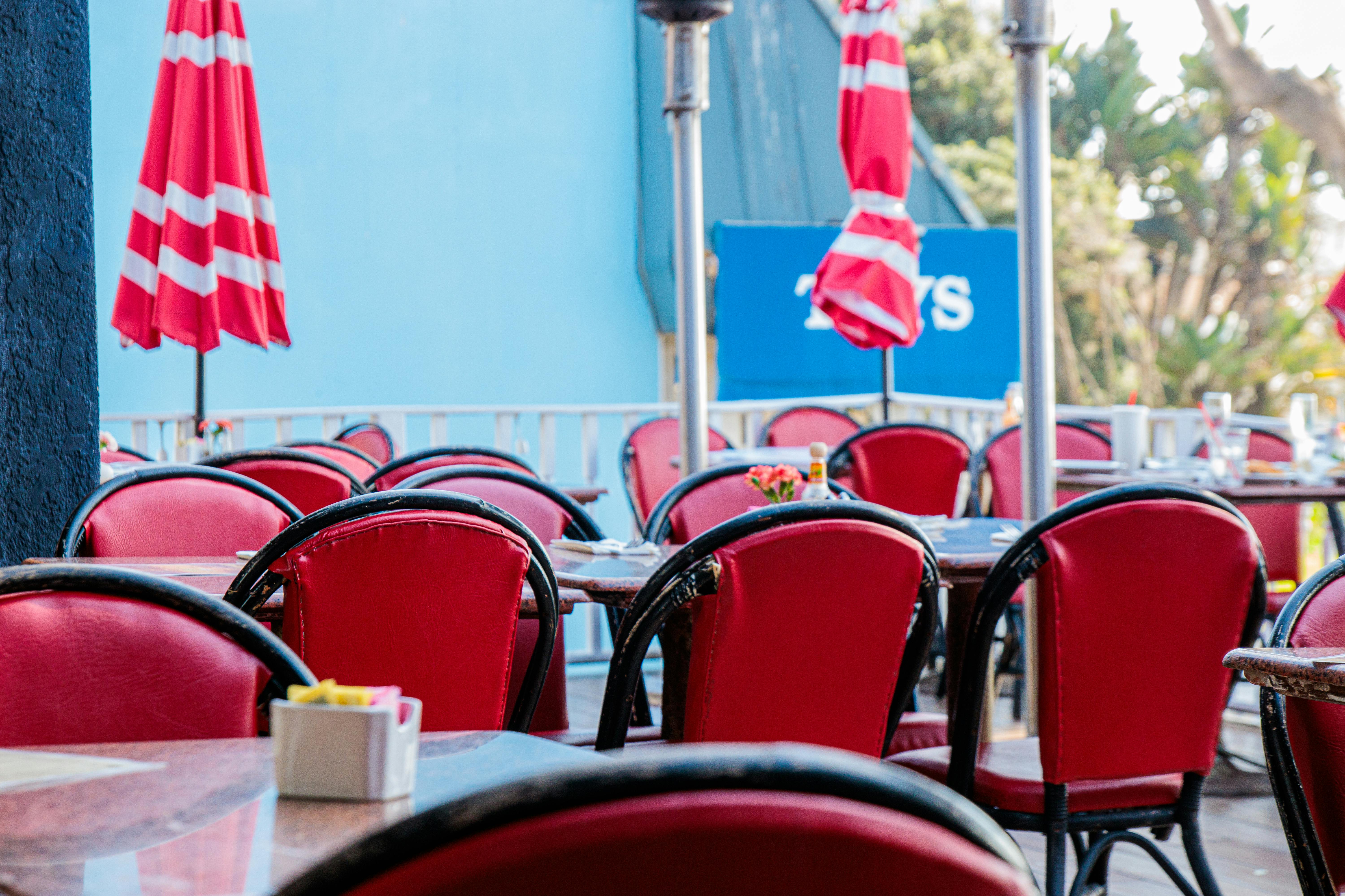Vibrant outdoor restaurant patio with colorful, weather-resistant chairs and umbrellas - restaurant furniture