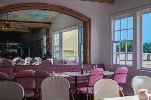 Charming restaurant interior with vintage decor and mirror reflection of dining area.