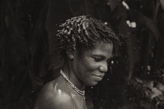 Captivating black and white portrait of a woman with water splashes and a serene expression.
