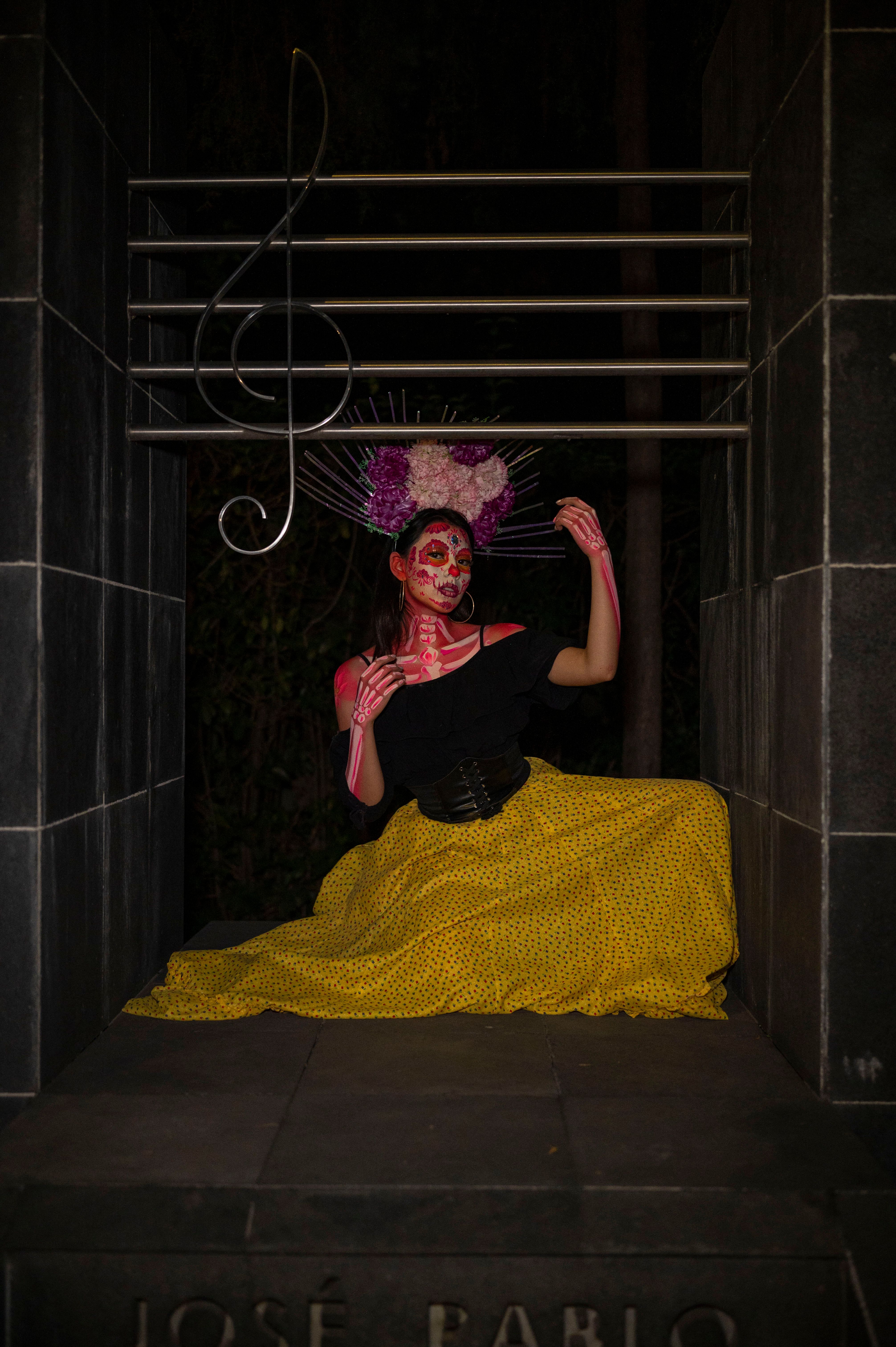 Traditional Día de los Muertos portrait of a woman as La Calavera Catrina wearing vibrant attire.
