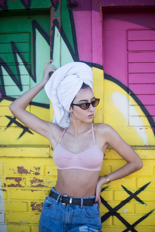 Woman With White Towel On Hair Standing and Leaning on Pink and Yellow Painted Wall