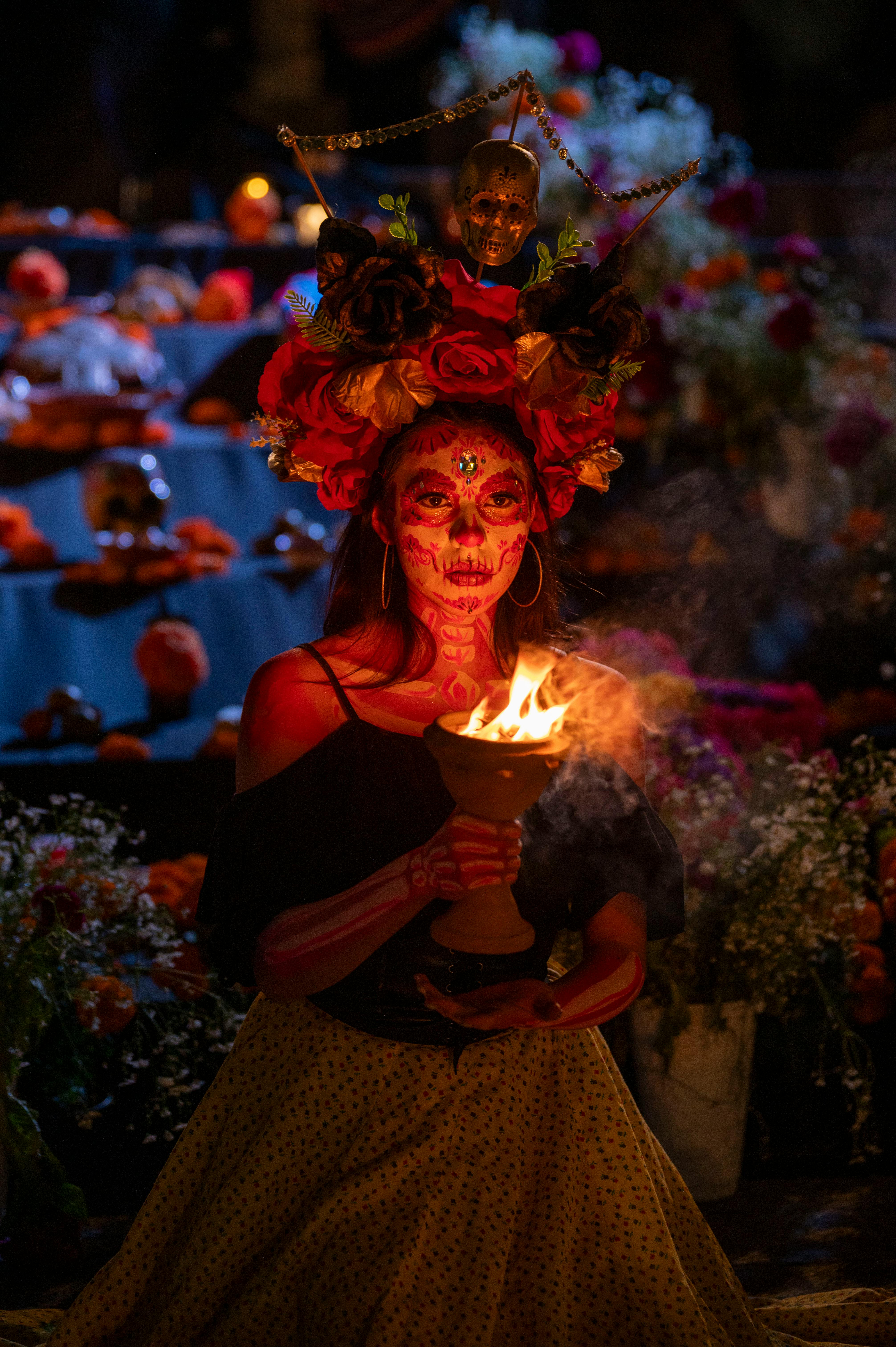 catrina illuminated by flame at night