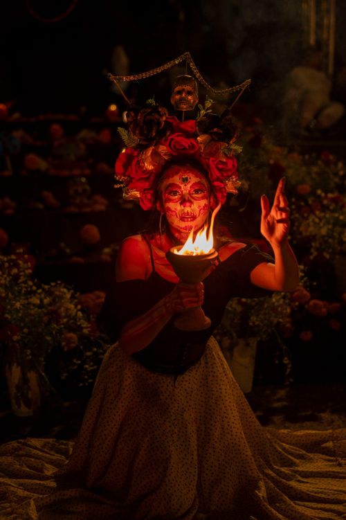 Free Woman with Catrina makeup holding a torch, celebrating Dia de los Muertos at night. Stock Photo
