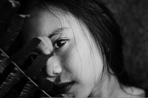 Free Close-up black and white portrait of a girl with a fern leaf. Stock Photo