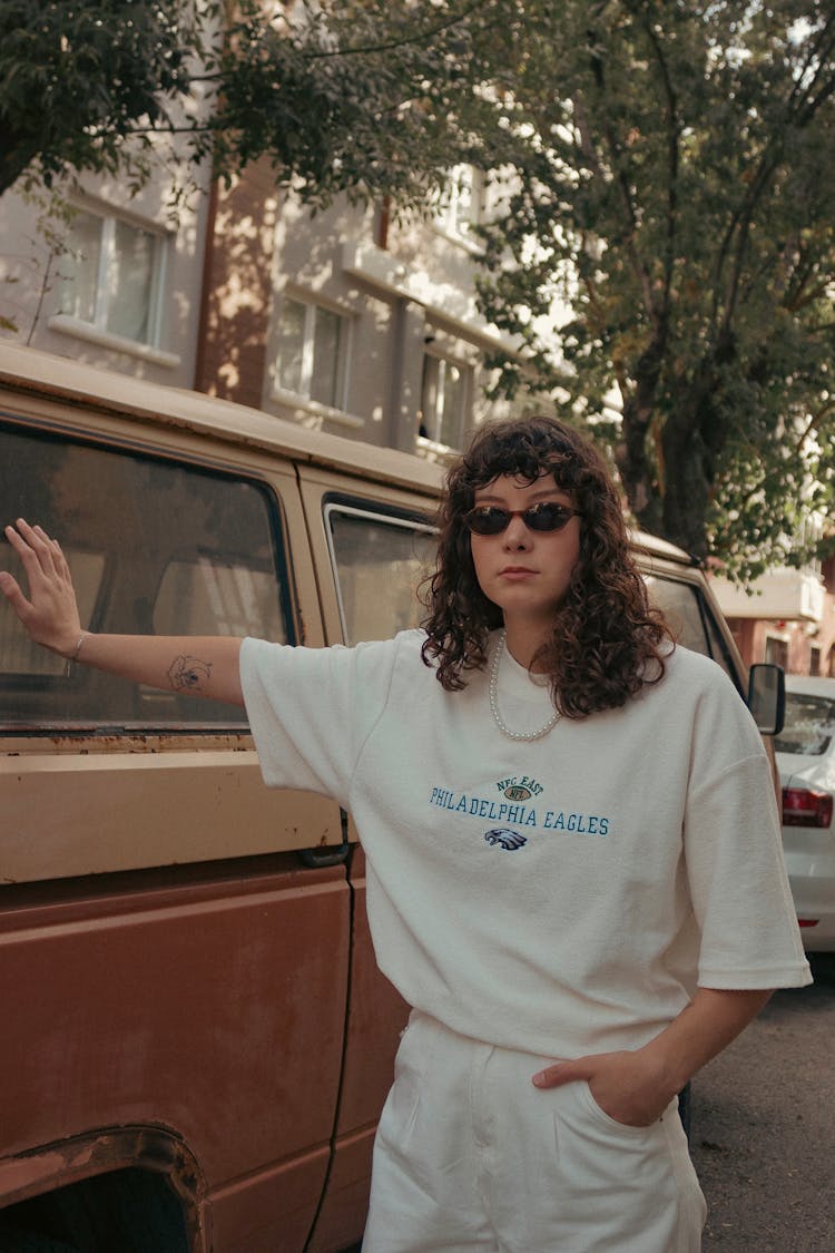 Young Woman Standing Next To An Old Van On The Street 