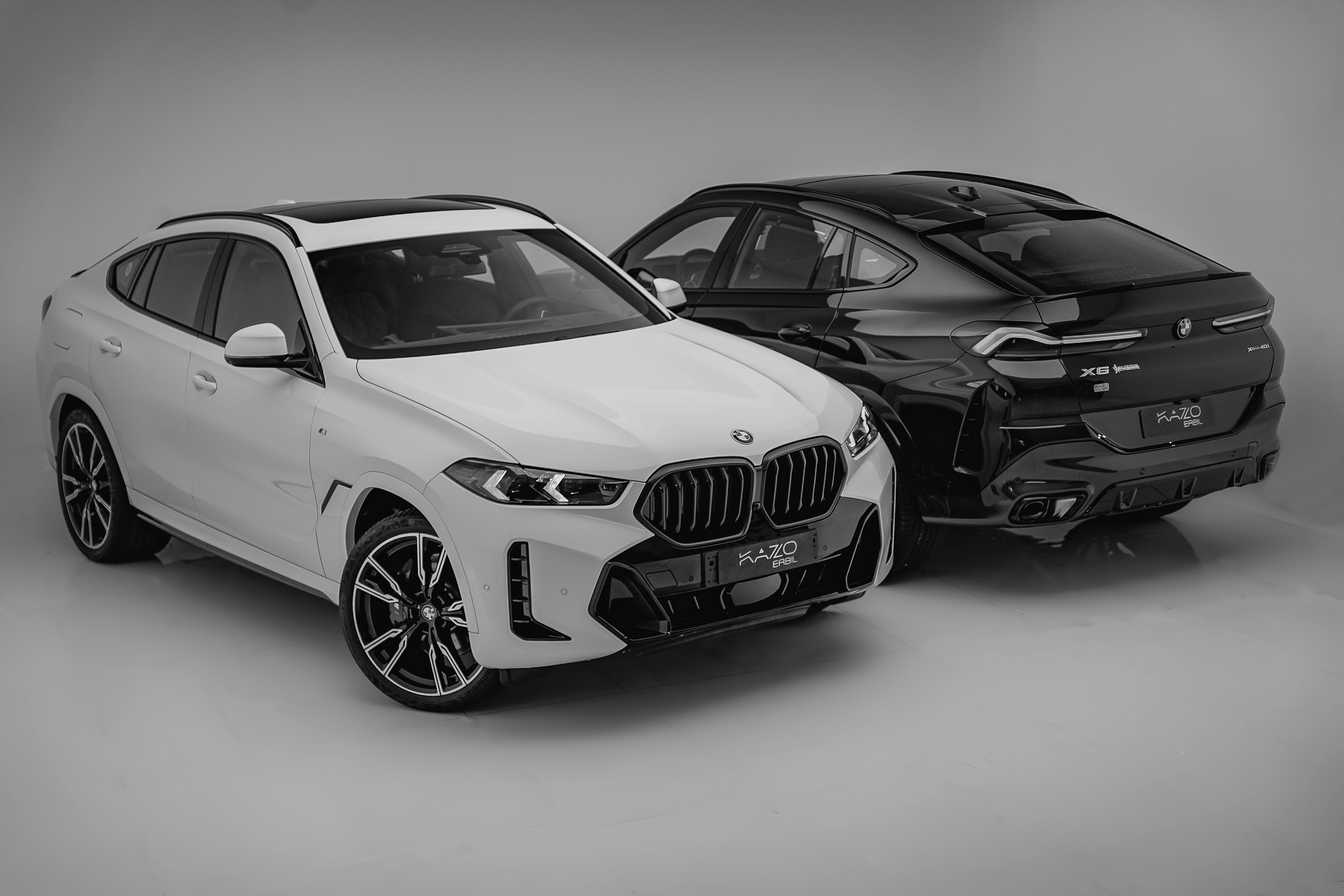 Two bmw suvs are shown in black and white · Free Stock Photo