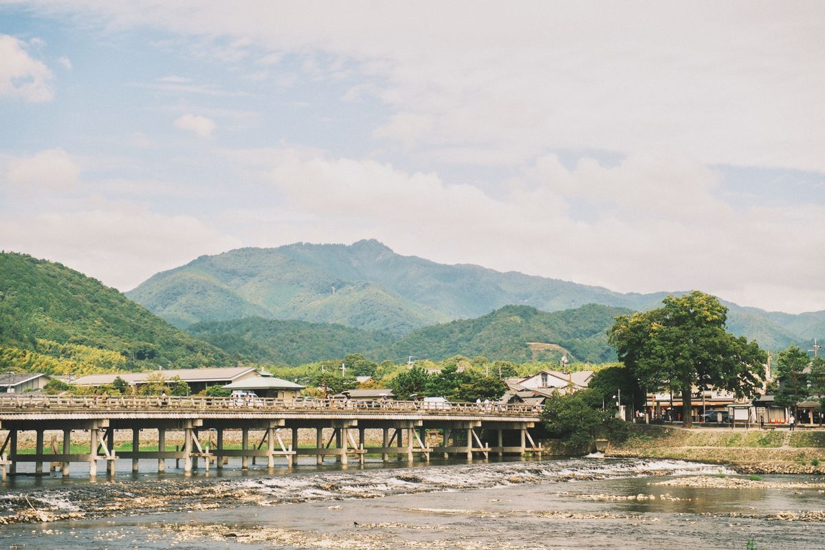 Serene landscape of Arashiyama with its picturesque bridge and forest