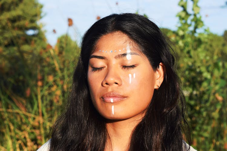 Portrait Of A Young Woman Standing Outside With Closed Eyes