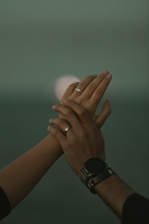 Close-up of Man and Woman Wearing Rings and Holding Hands 