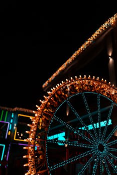 A vibrant Ferris wheel lit with neon lights against the night sky, creating a festive atmosphere.