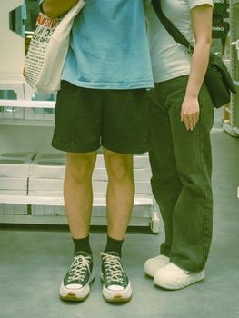 Couple in casual attire standing together inside a modern store.