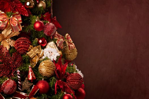 A beautifully decorated Christmas tree featuring red and gold ornaments with ample copy space.