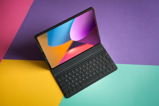 A tablet with a keyboard resting on vibrant, colorful paper backdrop. Perfect for tech themes.