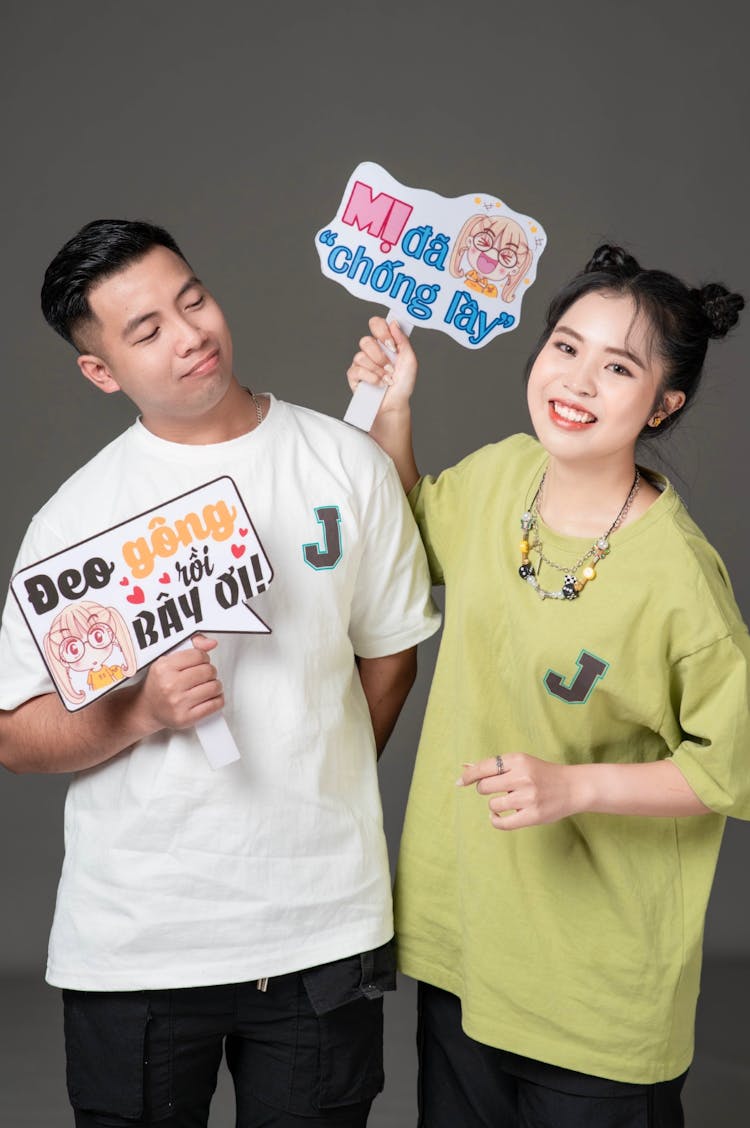 Couple In T-shirts Holding Signs