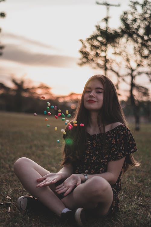 Vrouw In Zwarte Bloemen Top Spelen Met Snoepjes