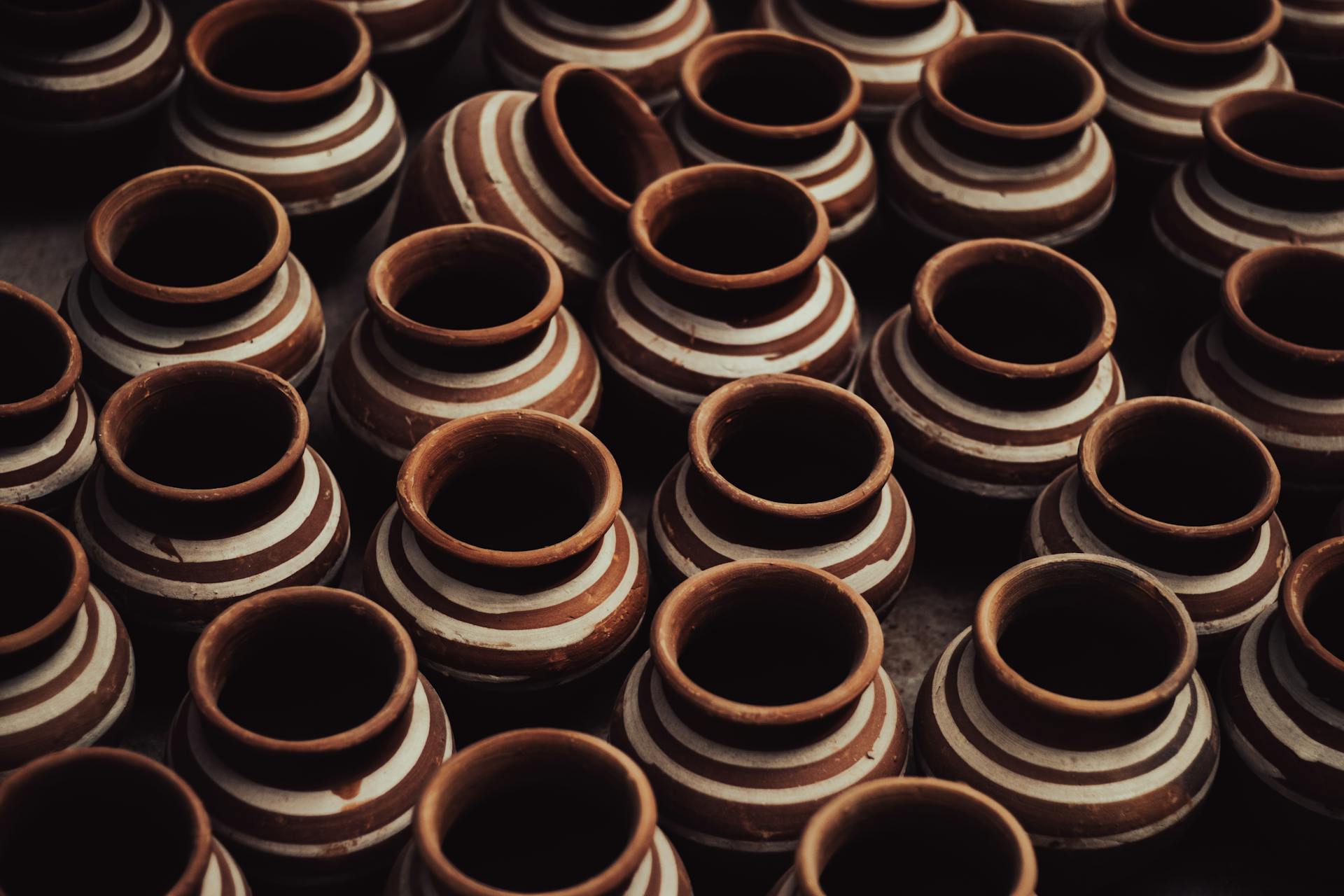 Close-up of handmade terracotta pots showcasing traditional craftsmanship with intricate patterns.