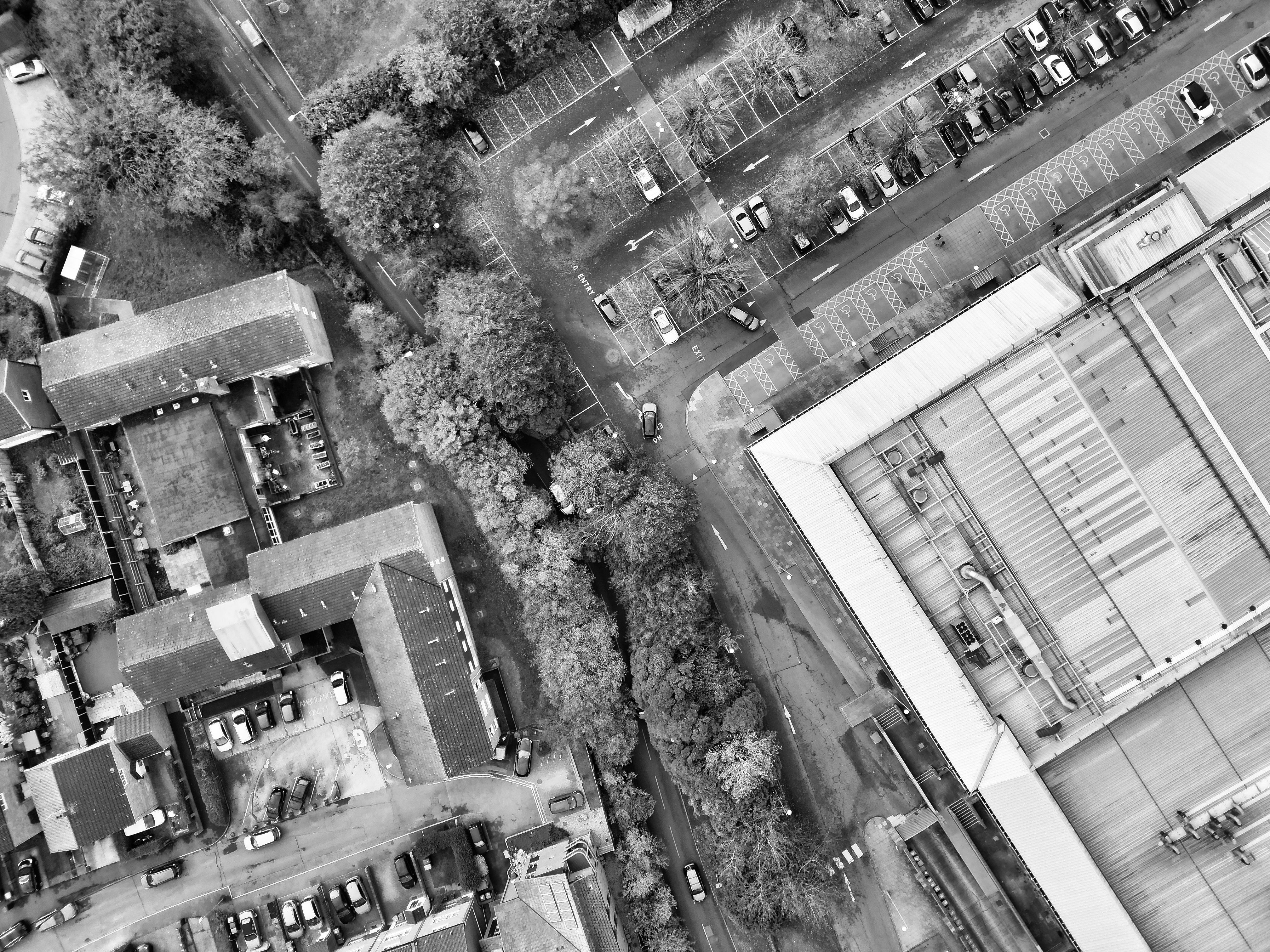 Black and white aerial view of Hertfordshire, showcasing buildings and parking areas.