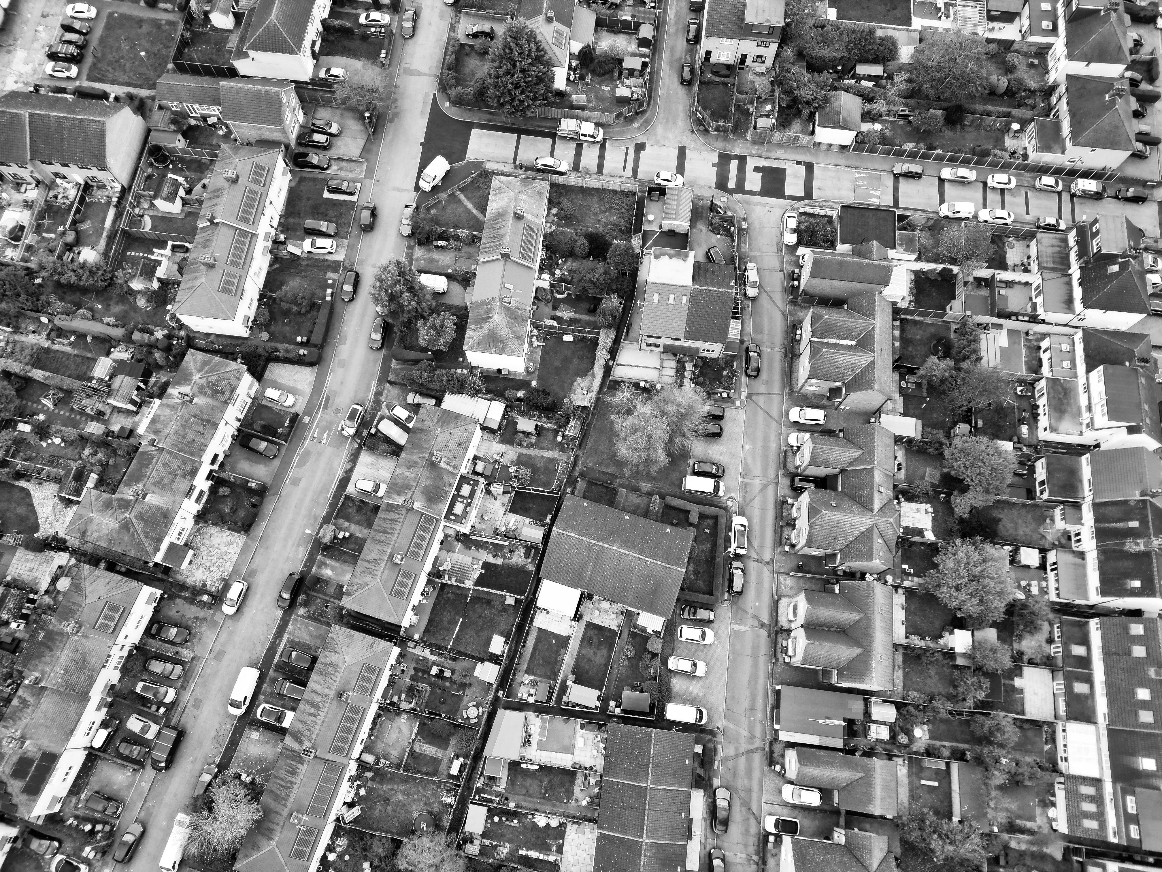 Drone-captured overhead shot of Hertfordshire's urban residential area in black and white.