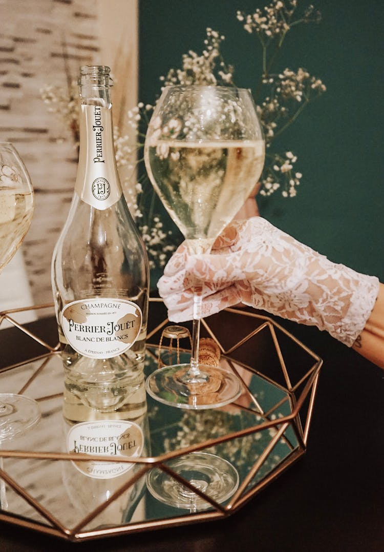 Woman Hand In Glove Holding Glass Of Champagne