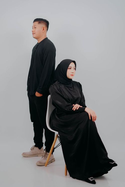 Free Elegant studio portrait of a fashionable man and woman dressed in black with a white background. Stock Photo