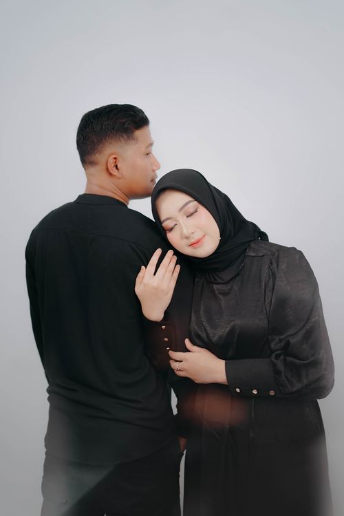 Free Portrait of a couple embracing warmly, woman in hijab leaning on man's shoulder. Stock Photo