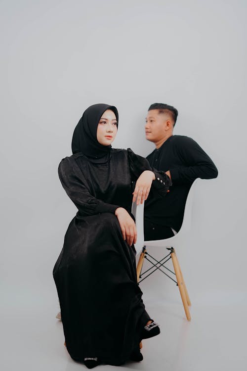 Man and Woman in a Headscarf Sitting on Chairs