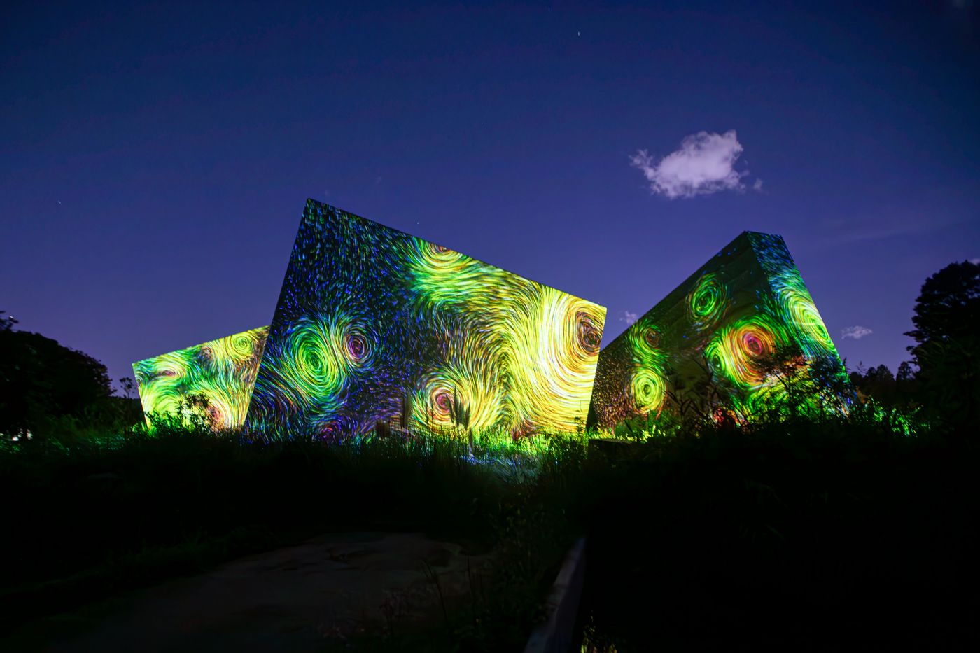 Immersive light projections washing over architecture at night