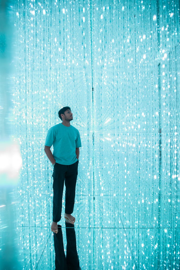 Man Standing With Hands In Pockets On Shiny Background