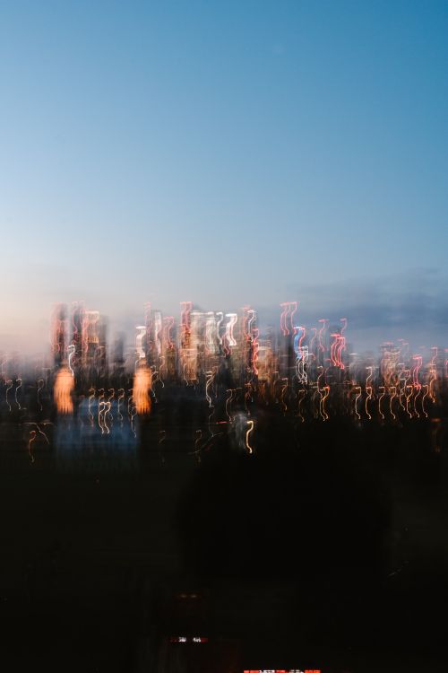 Free An artistic blur of city lights against a twilight sky, creating a dreamlike urban cityscape. Stock Photo