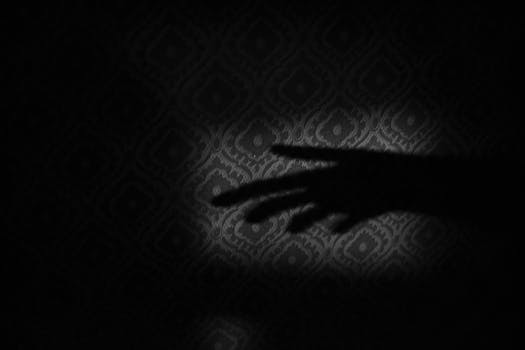 Shadow of a hand against a patterned background, creating an artistic and mysterious ambiance.