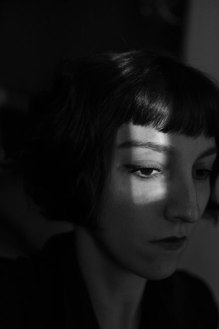 Emotive black and white portrait of a woman with shadows on her face.