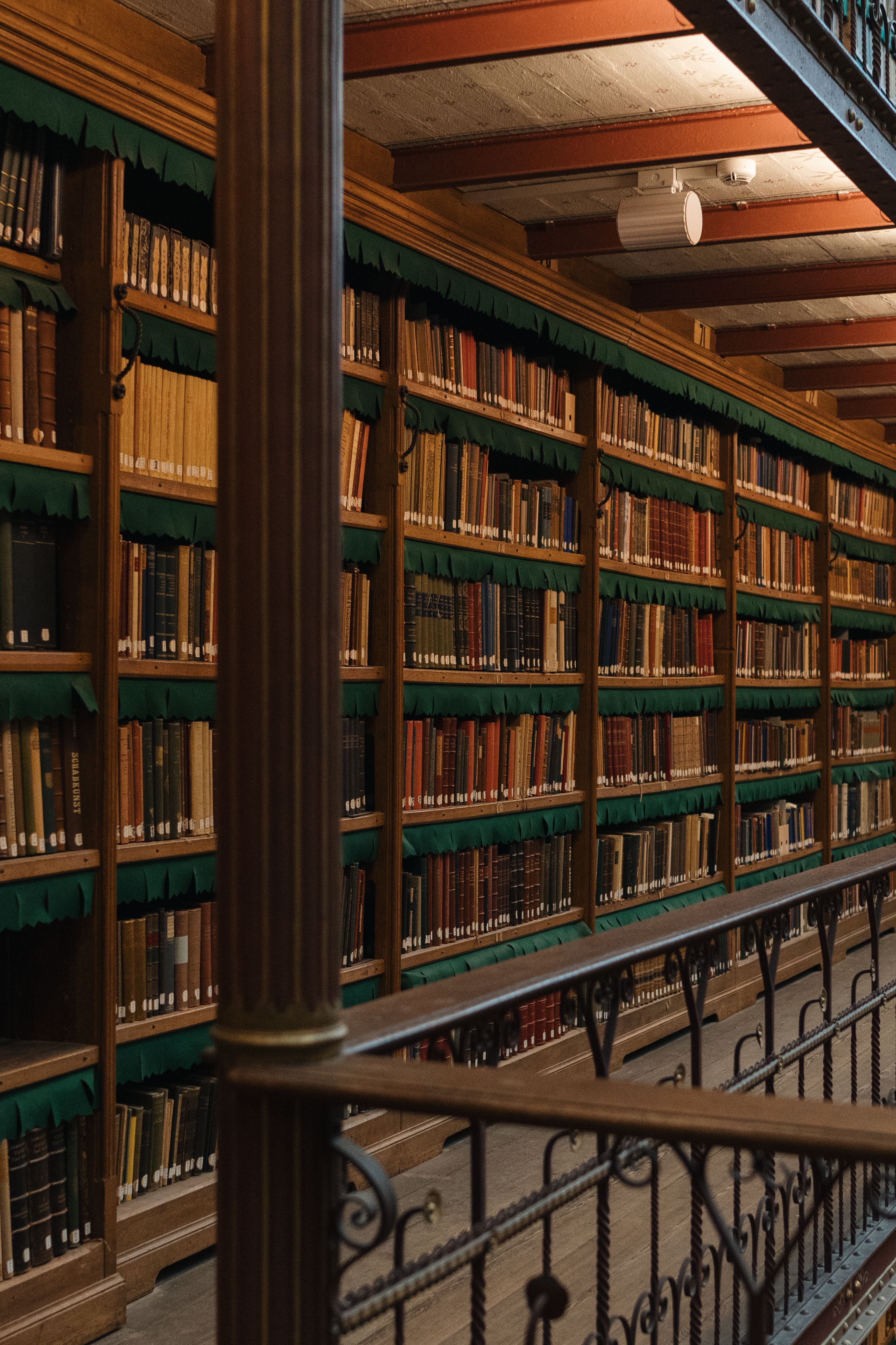Rows of old books filling wooden library shelves