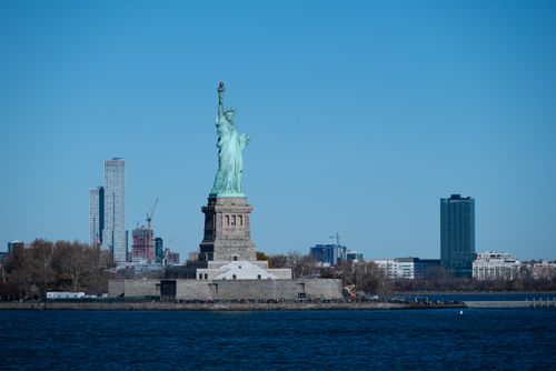 Free A stunning view of the Statue of Liberty with the New York City skyline in the background. Stock Photo