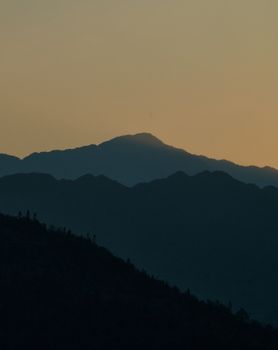 Serene landscape with silhouetted hills at dusk, showcasing natural beauty and tranquility.