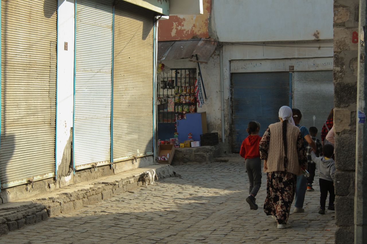 candid street scene showing a family walking down cobblestone streets