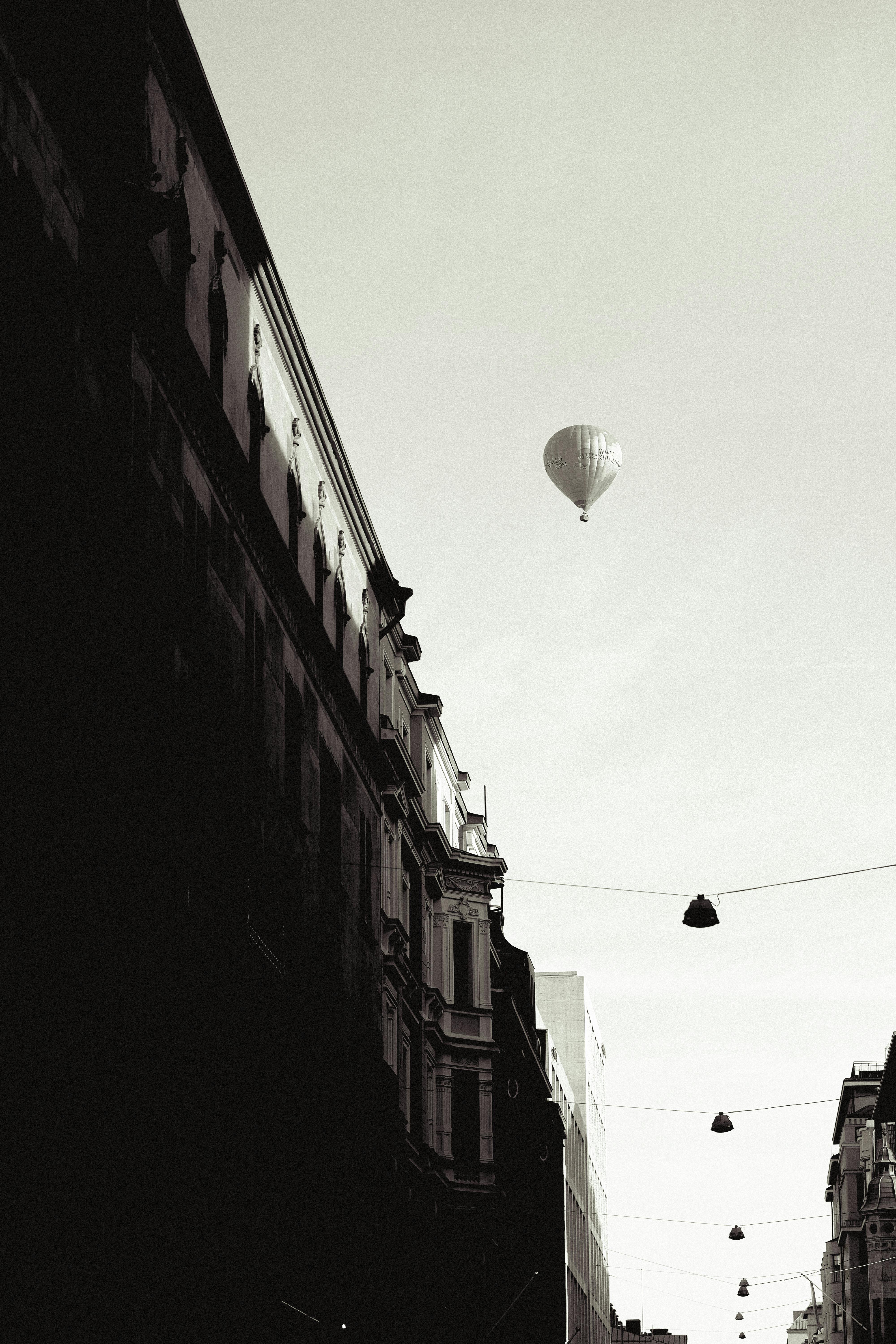 Black and white photo of Helsinki street with a hot air balloon in the sky.