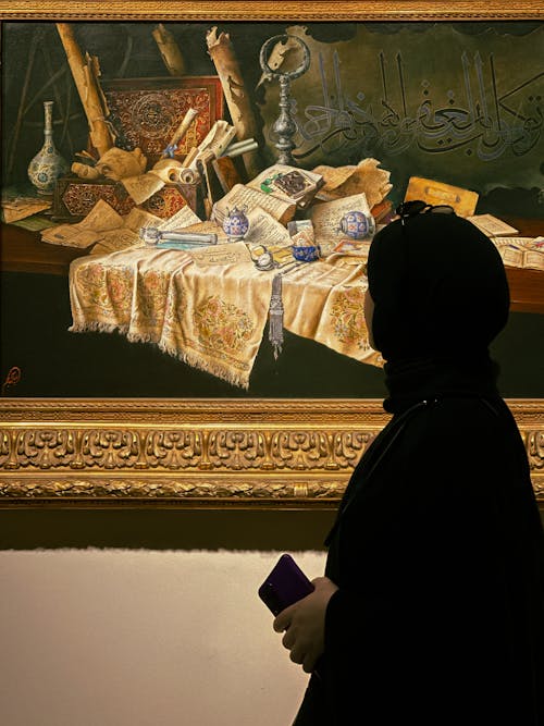 Woman in Hijab Standing by Painting in Art Museum