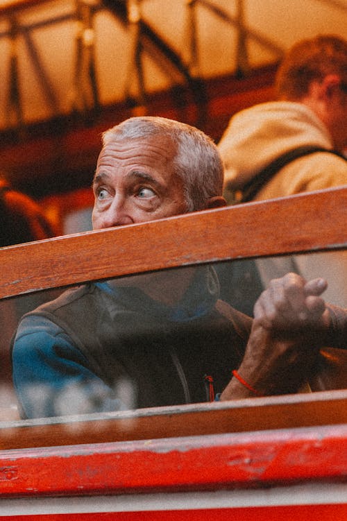 Candid Photo of a Man Sitting by the Window 