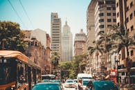 晴朗的天空下，城市街景繁忙，摩天大楼高耸，交通繁忙