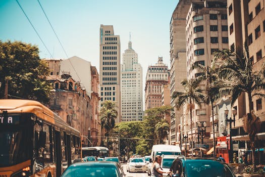 晴朗的天空下，城市街景繁忙，摩天大楼高耸，交通繁忙